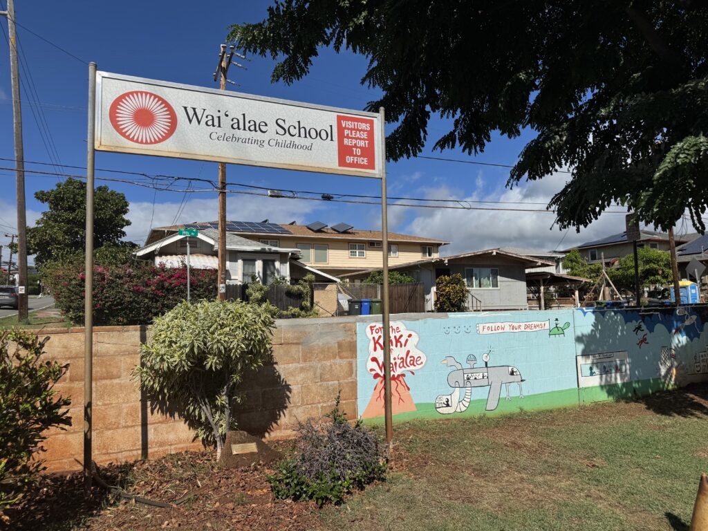 Welcome sign at Waiʻalae School with the name of the school and motto "Celebrating Childhood"