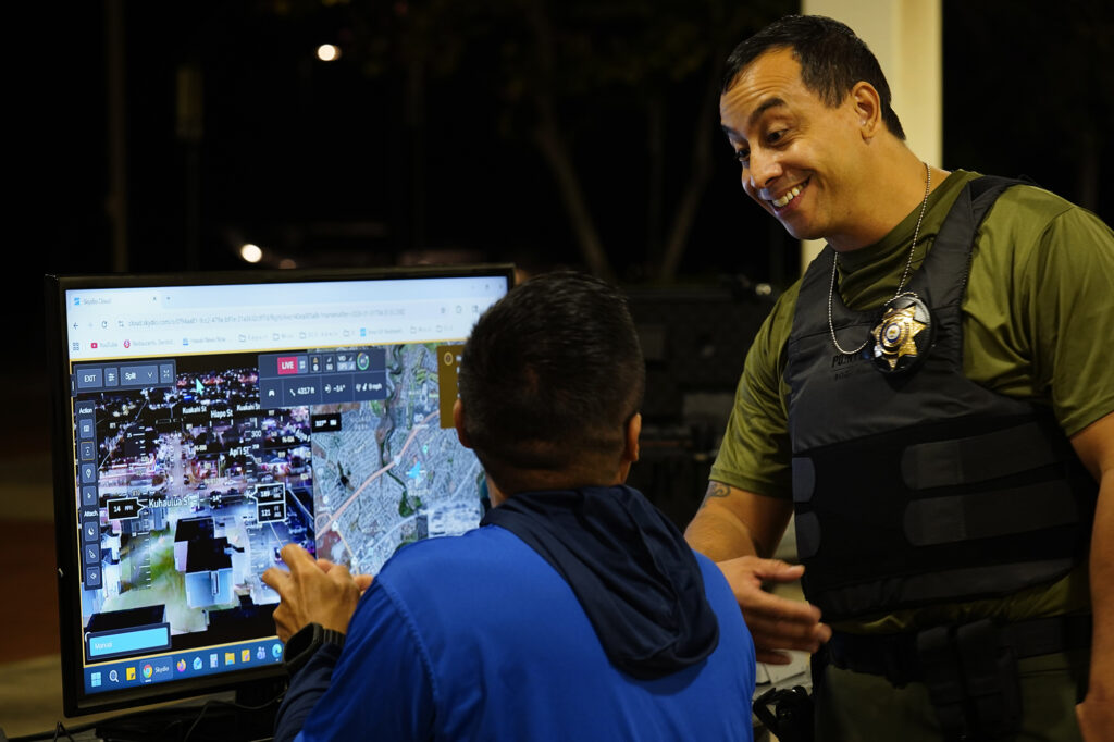 Department of Law Enforcement Director Mike Lambert talks with a drone pilot before taking journalists on a ride along Wednesday, Dec. 31, 2025, in Waipahu. New laws, the use of aerial drones and citizens heeding the dangers of fireworks noticeably  curbed the annual personal pyrotechnics. (Kevin Fujii/Civil Beat/2025)
