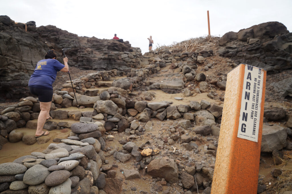 Protect Kahoʻolawe ʻOhana (PKO) Davianna Pomaika'i McGregor walks up a maintained trail between warning signs Monday, Jan. 5, 2026, in Hakioawa. PKO celebrates the 50th year of sovereign land. (Kevin Fujii/Civil Beat/2026)
