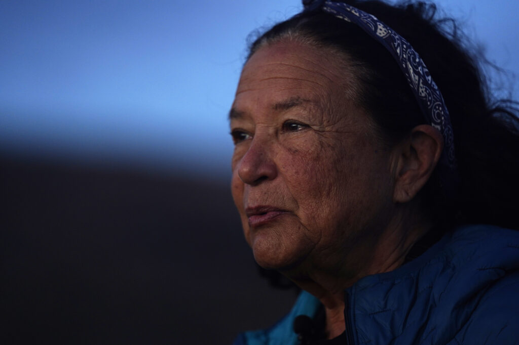 The sun begins to illuminate Protect Kahoʻolawe ʻOhana (PKO) Davianna Pomaika‘i McGregor before performing the sunrise protocol Monday, Jan. 5, 2026, in Hakioawa. PKO celebrates the 50th year of sovereign land. (Kevin Fujii/Civil Beat/2026)