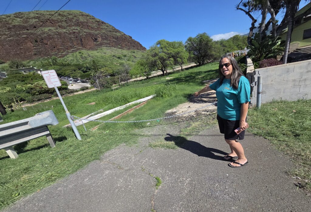 Lena Spain-Suzuki points toward the property along Farrington Highway where the Waiʻanae Moku Kupuna Council hopes to develop a kūpuna kauhale.