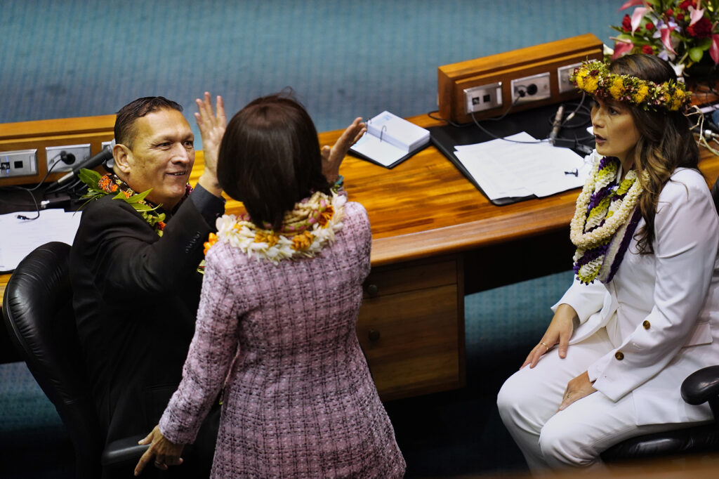 Sens. Kurt Fevella, from left, high fives Donna Kim as Samantha DeCorte looks on before the Hawaiʻi State Legislature opens Wednesday, Jan. 21, 2026, in Honolulu. (Kevin Fujii/Civil Beat/2026)