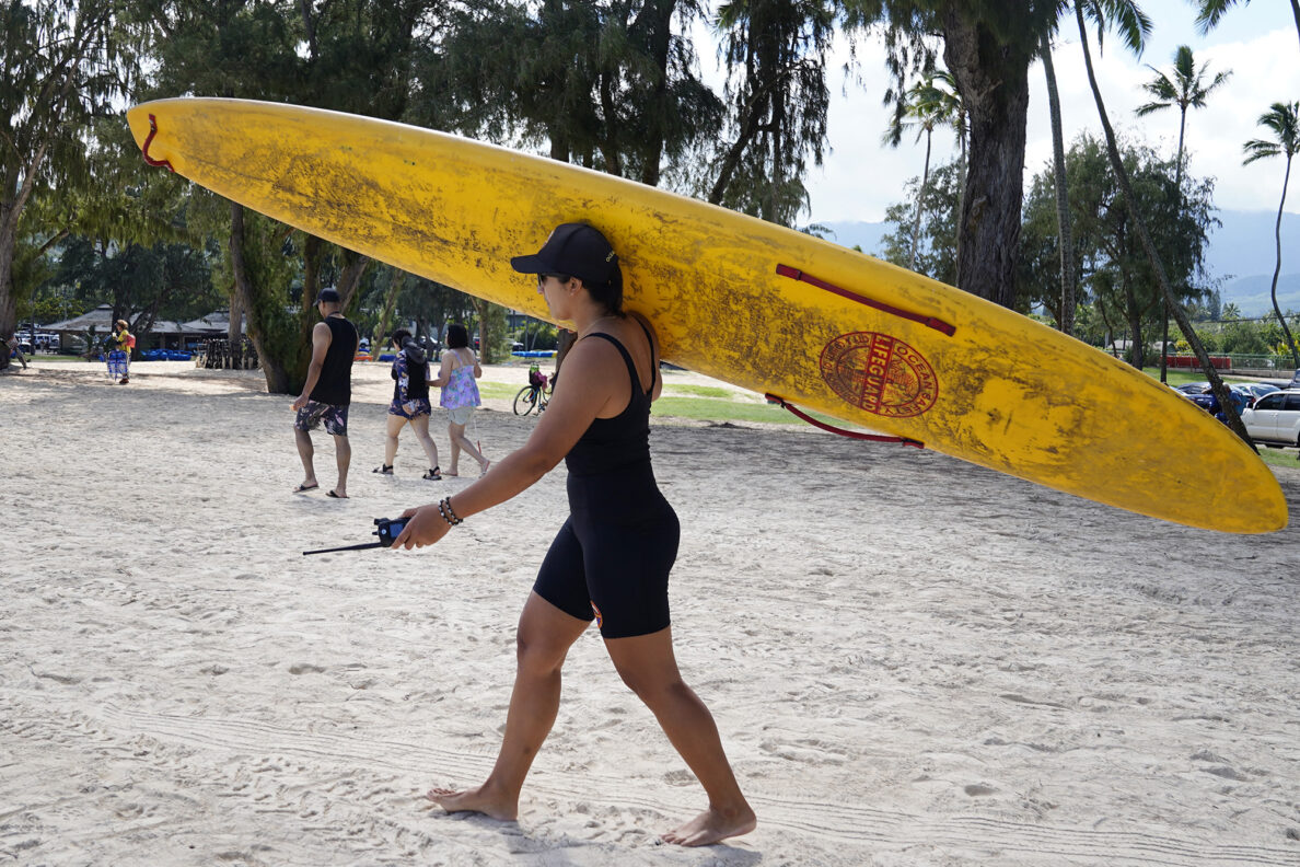 Honolulu Ocean Safety Departmen Lt. Chelsea Kahalepauole-Bizik shoulders a rescue board at Kailua Beach Park Tuesday, Jan. 27, 2026, in Kailua. (Kevin Fujii/Civil Beat/2026)