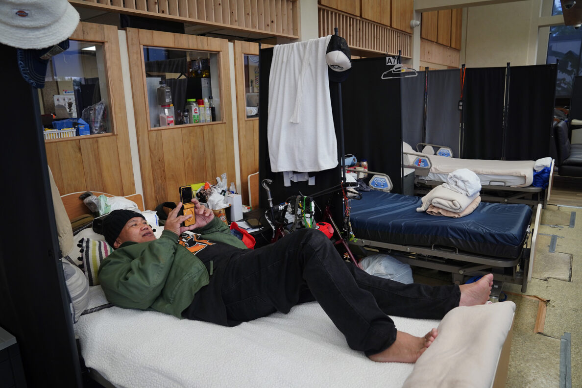 Tony Capati watches a video at the ʻAʻala Respite Center Monday, Jan. 26, 2026, in Honolulu. (Kevin Fujii/Civil Beat/2026)