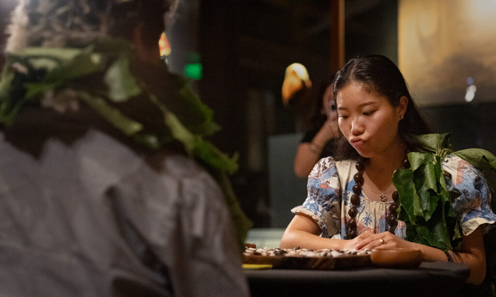 Yuna Inoue, of Hawaiʻi Island, focuses on a move against Oʻahu’s Kapena Baptista, left, during the semifinals of the inaugural Ka Makou Kōnane Invitational Tournament at the Bishop Museum Friday, Feb. 13, 2026, in Honolulu. (Kevin Fujii/Civil Beat/2026)