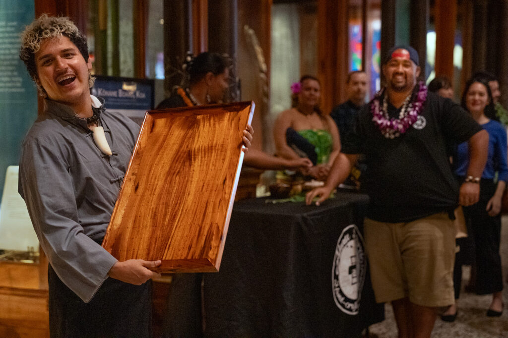 Kapena Baptista holds the replica Papamū Kūpuna made by Wallace Akua of Akua Boards for winning the inaugural Ka Makou Kōnane Invitational Tournament at the Bishop Museum Friday, Feb. 13, 2026, in Honolulu. (Kevin Fujii/Civil Beat/2026)