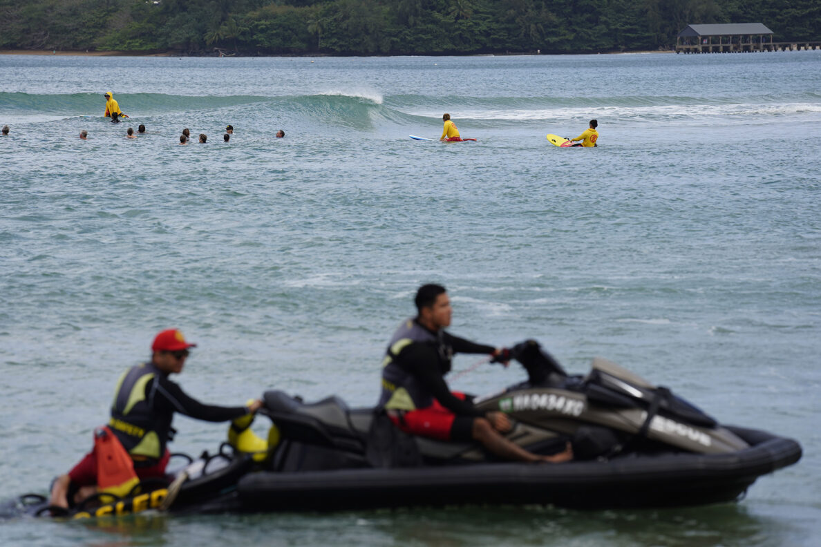 Kaua‘i Ocean Safety Bureau lifeguards on a jet ski and sled offer assistance if needed to ocean safety educator Bruce “Hoppo” Hopkins of Australia, Okinawa Lifesaving Association lifeguards while leading a group of rip-current clinic participants at Waiʻoli Beach Park Wednesday, Feb. 18, 2026, in Hanalei. (Kevin Fujii/Civil Beat/2026)