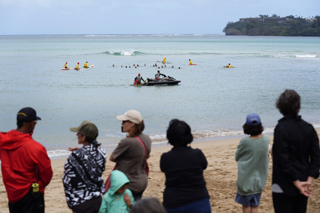 Kaua‘i Ocean Safety Bureau lifeguards on a jet ski and sled offer assistance if needed to ocean safety educator Bruce “Hoppo” Hopkins of Australia, Okinawa Lifesaving Association lifeguards while leading a group of rip-current clinic participants at Waiʻoli Beach Park Wednesday, Feb. 18, 2026, in Hanalei. (Kevin Fujii/Civil Beat/2026)