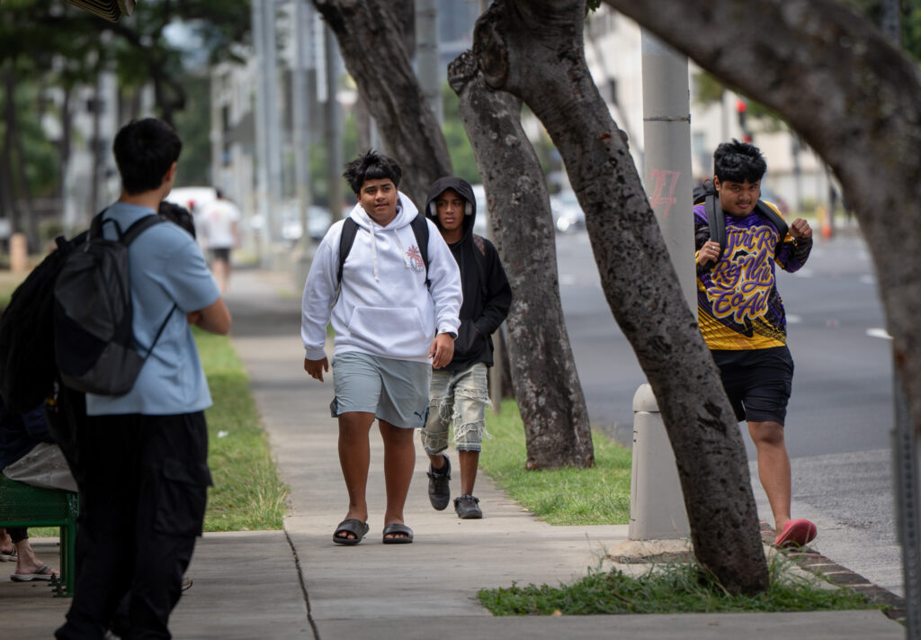 Students from McKinley High School walk up to the bus stop at King and Pensacola Sts in Honolulu, Thursday, Feb. 19, 2026. (Craig Fujii for Civil Beat)
