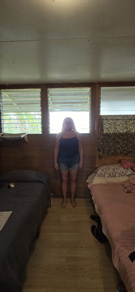 Resident of Hale Maluhia Women's Shelter, Kiona Boyd, standing in front of the windows for scale. Fire code requires that the sill of exit windows be no more than 44 inches, or 3.6 feet from the ground. Boyd is 5 feet 11 inches.