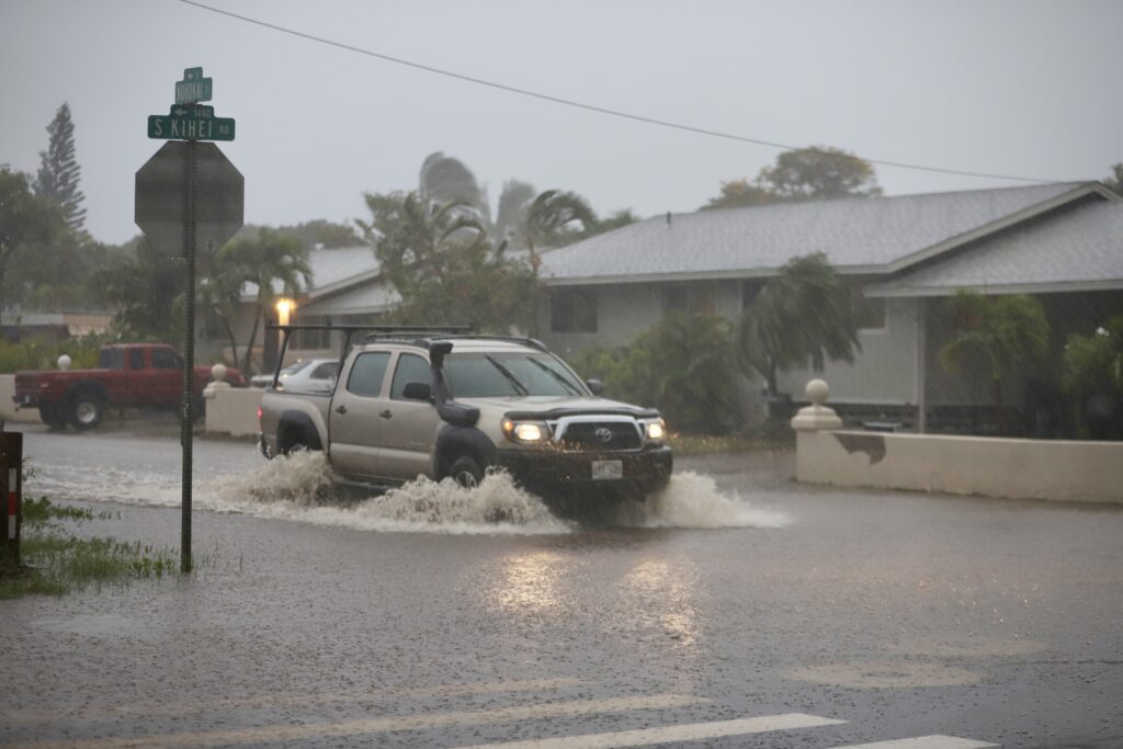 A Toyota truck drives through flooded roads in residential Kīhei.