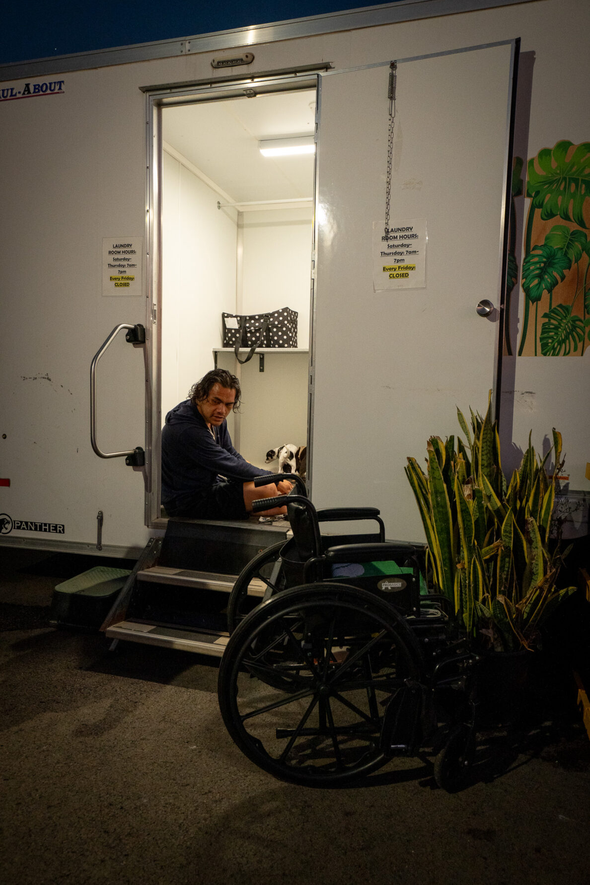 Kaisa Tai (cq) waits for his laundry to finish in the doorway of the laundry facilities at Ho'okahi Leo Kauhale. His wheelchair sits outside the structure.