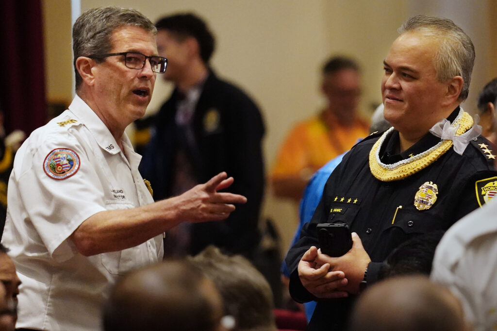 Honolulu Emergency Services Department Director Jim Ireland, left, talks story with Rade Vanic, Interim Chief of Police, before Mayor Rick Blangiardi’s State of City Wednesday, March 18, 2026, in Honolulu. (Kevin Fujii/Civil Beat/2026)