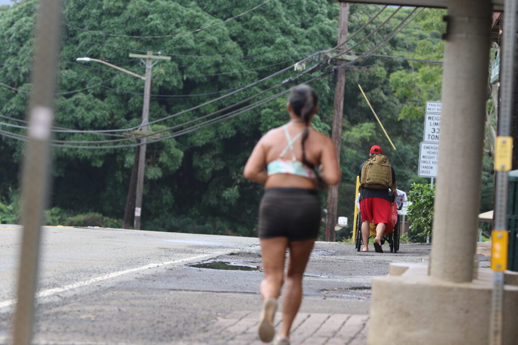 Brandon Delgado Dalumpinis pushes his father, Frank Smith, toward his senior living facility on the North Shore on Saturday.