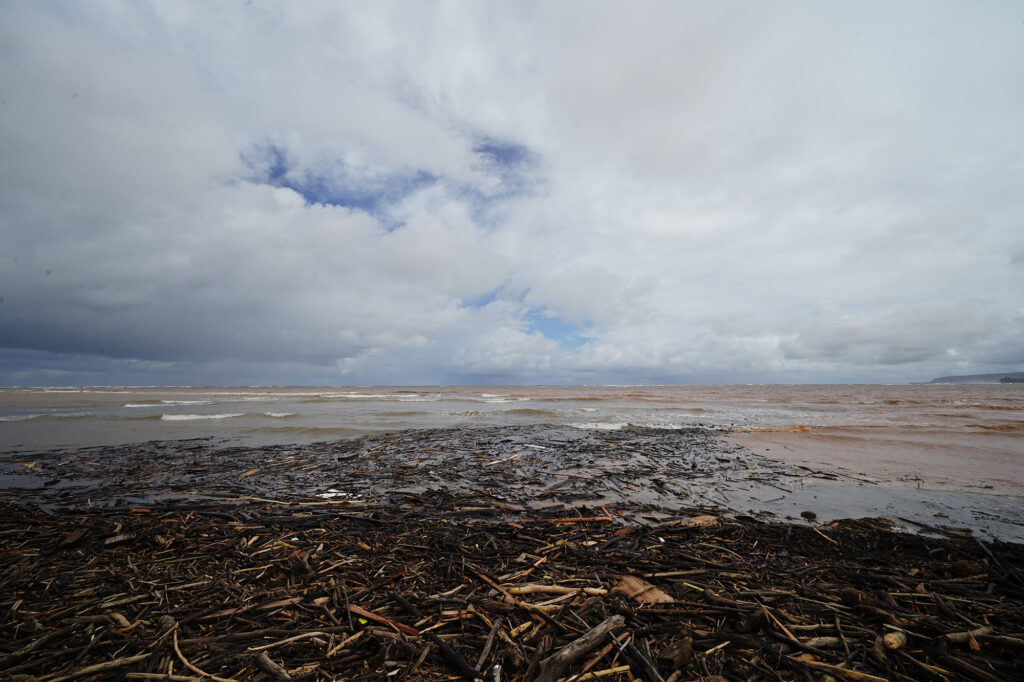 Debris on Pu‘uiko Beach and in the water is photographed Monday, March 23, 2026, in Waialua. A second Kona low storm brought heavy rain after the previous week’s downpour and high winds. (Kevin Fujii/Civil Beat/2026)