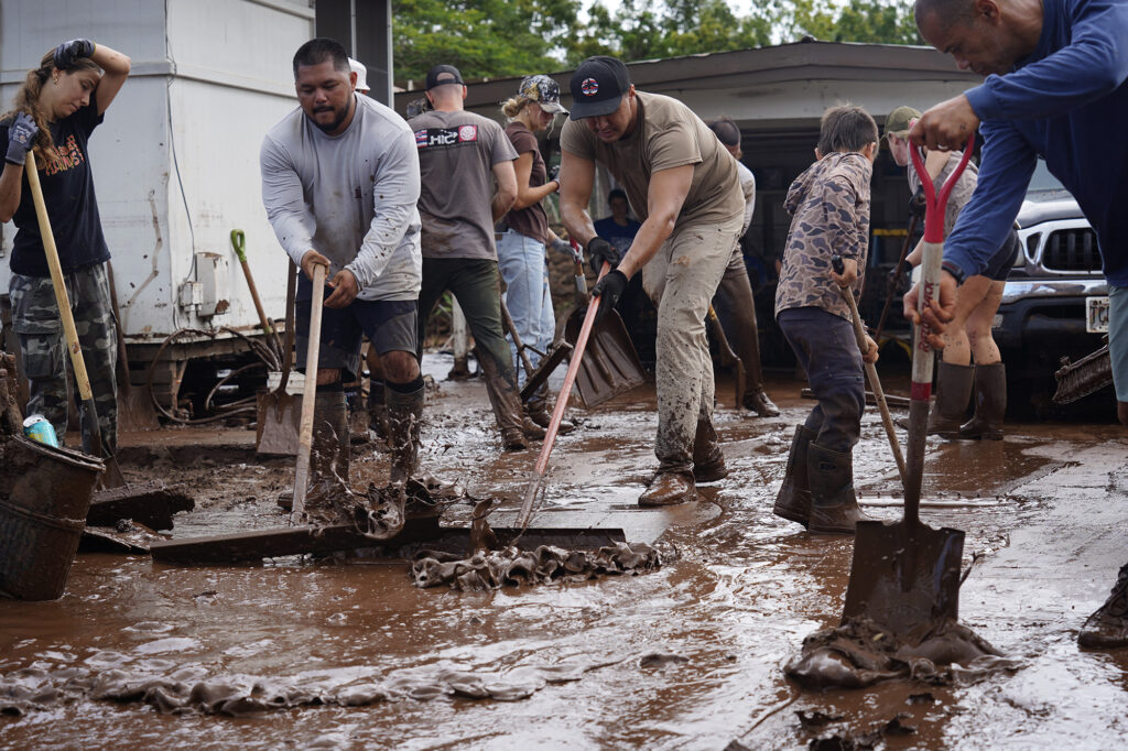 Volunteers push out mud at a Haona Street home Monday, March 23, 2026, in Waialua. A second Kona low storm brought heavy rain after the previous week’s downpour and high winds. (Kevin Fujii/Civil Beat/2026)