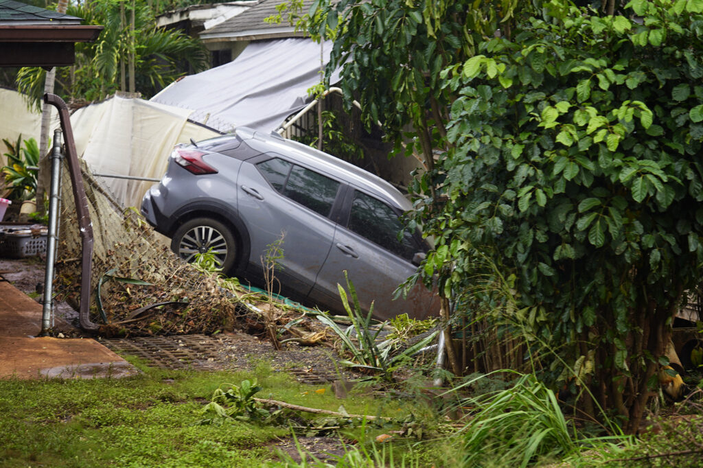 A car rests where flood waters deposited it near Waialua Beach Road Monday, March 23, 2026, in Waialua. A second Kona low storm brought heavy rain after the previous week’s downpour and high winds. (Kevin Fujii/Civil Beat/2026)