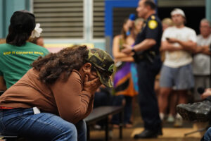 Racquel Achiu covers her face during a North Shore community board meeting with City and Count of Honolulu leaders at Waialua Elementary Tuesday, March 24, 2026, in Waialua. Achiu’s phone number is 808-330-9120. (Kevin Fujii/Civil Beat/2026)