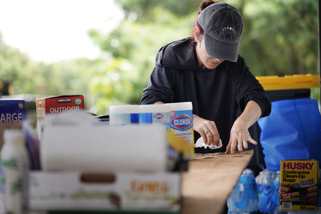 Hoku Hale aesthetician Sarah Matthews cleans mud off photos she found in Otake Camp Wednesday, March 25, 2026, in Waialua. Matthew’s studio was flooded in the Ka‘ala Healing Arts building on the bank of the Kaukonahua Stream. Sarah’s phone number is 808-436-6217. She has been flooded three times. This third and most recent flood, she didn’t move things off her floor and take important paperwork. She said she doing it twice before with little to no damage made her complacent. (Kevin Fujii/Civil Beat/2026)