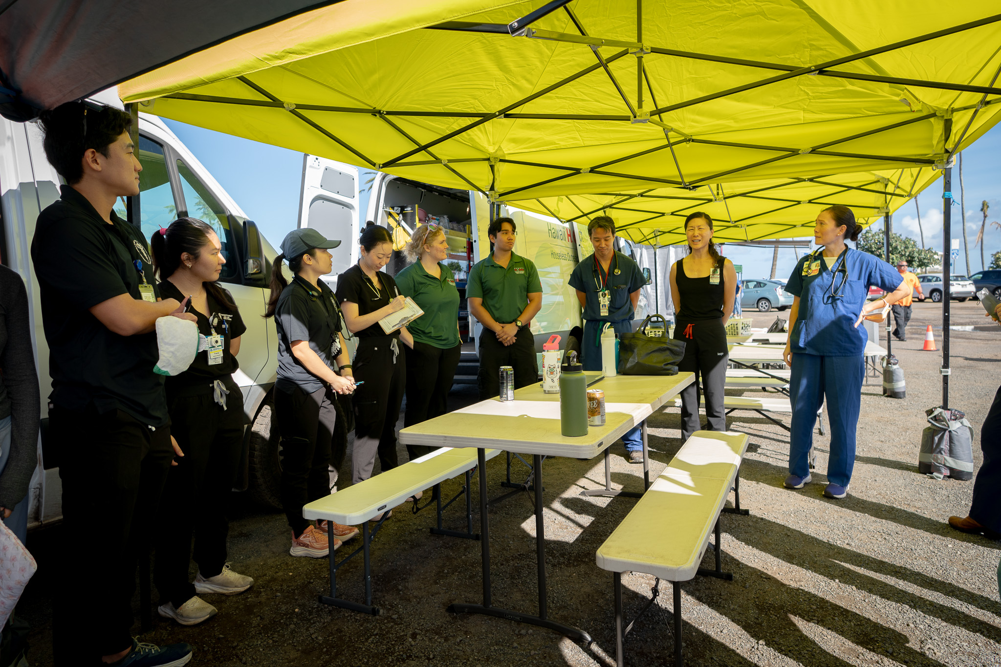 Student doctors and attending physicians, right, prepare for their clinic at Ali'i Beach Park in Haleiwa March 26, 2026. The students provided care to local residents affected by recent flooding. (Craig Fujii/Civil Beat/2026)