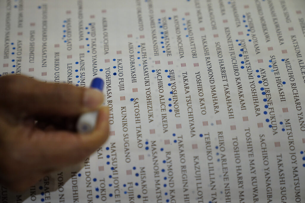 My father Kazuo Fujii stamps his name last Thursday, April 9, 2026, in Honolulu. (Kevin Fujii/Civil Beat/2026)