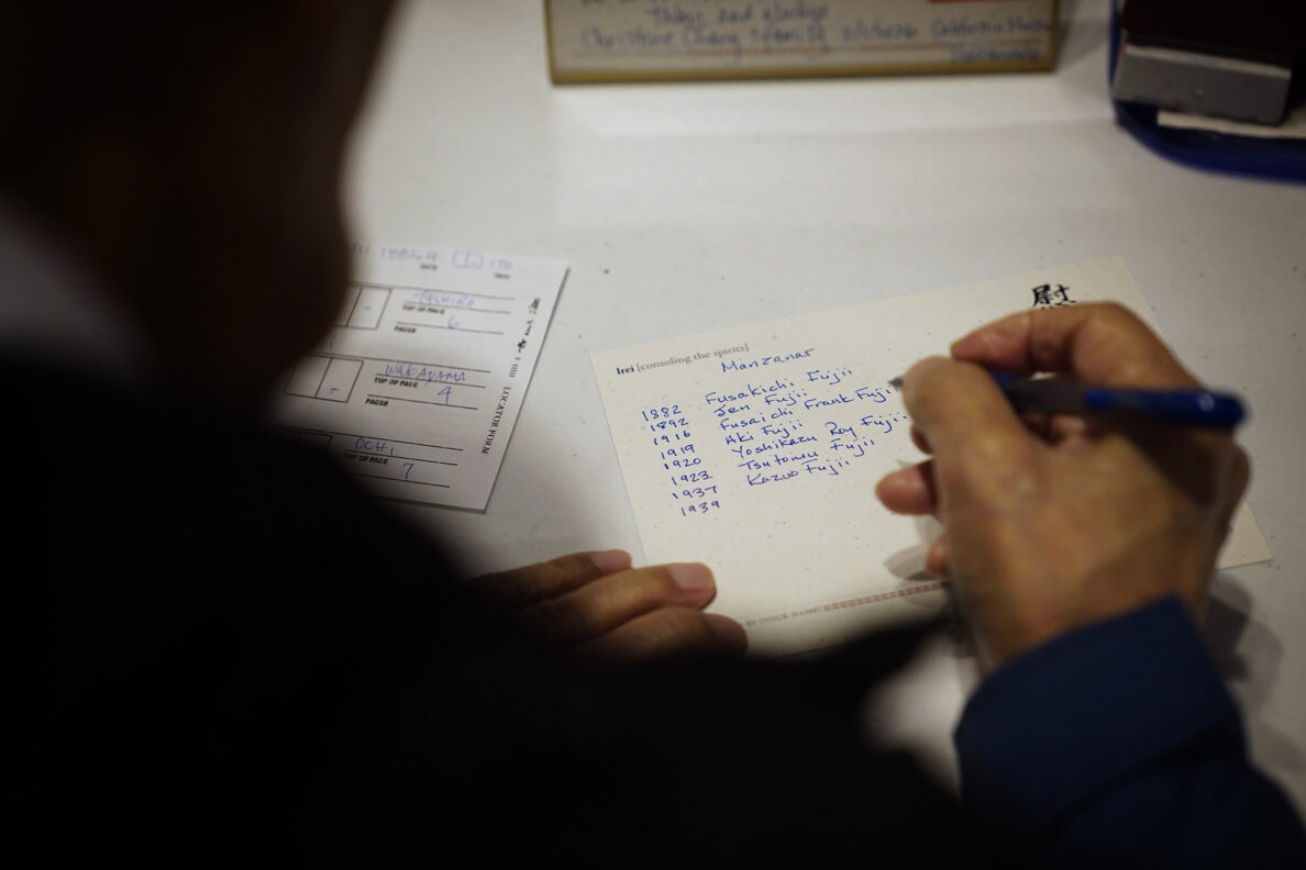 Kazuo Fujii writes the names and birth years of our relatives he placed a Japanese hanko (stamp) in the Ireichō Thursday, April 9, 2026, at the Japanese Culture Center of Hawaiʻi in Honolulu. (Kevin Fujii/Civil Beat/2026)