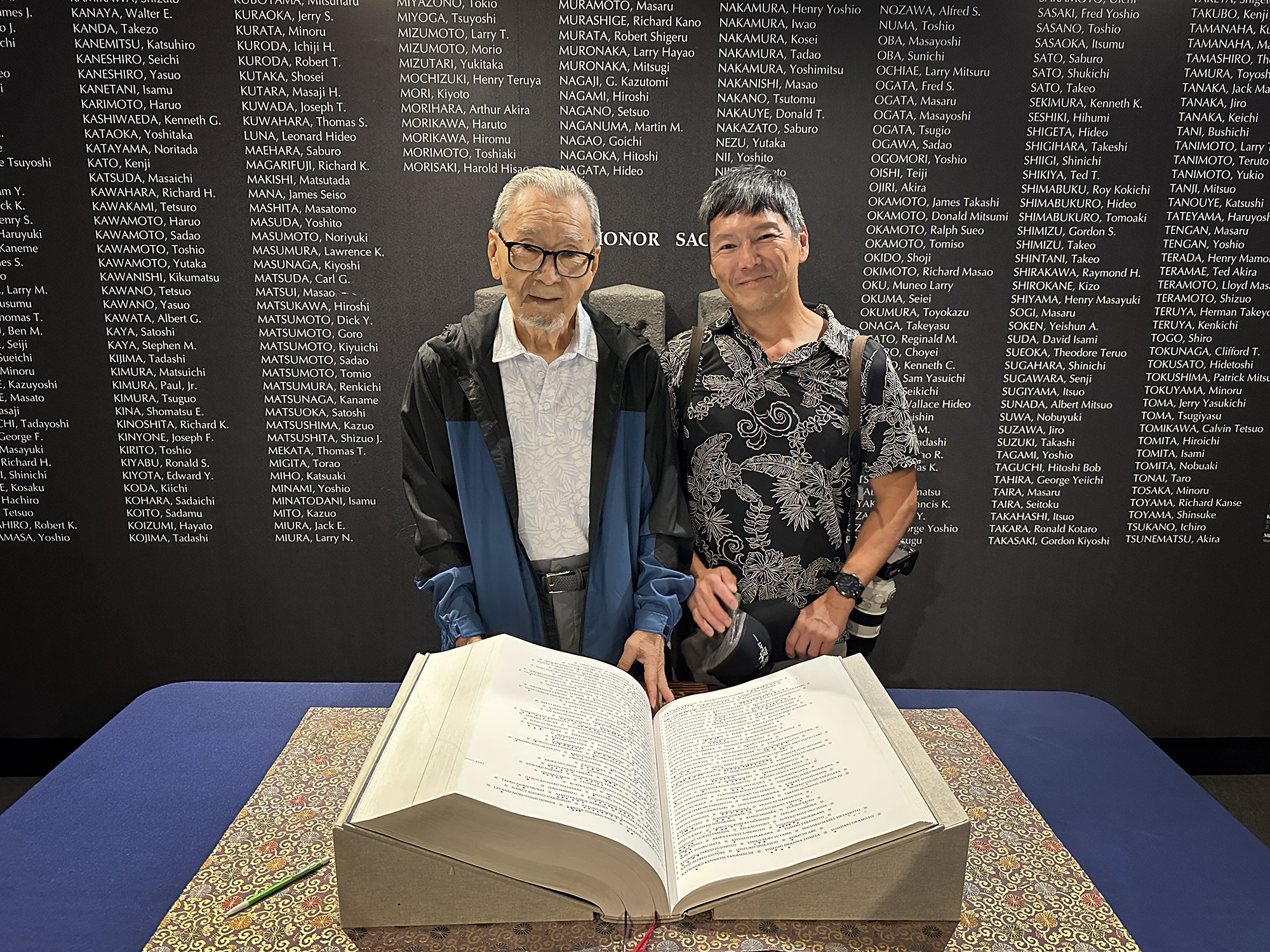 Kazuo Fujii and Kevin Fujii stand behind the Ireichō, a book monument containing the names of 125,284 individuals of Japanese ancestry incarcerated during World War II, Thursday, April 9, 2026, at the Japanese Culture Center of Hawaiʻi in Honolulu. (Kevin Fujii/Civil Beat/2026)