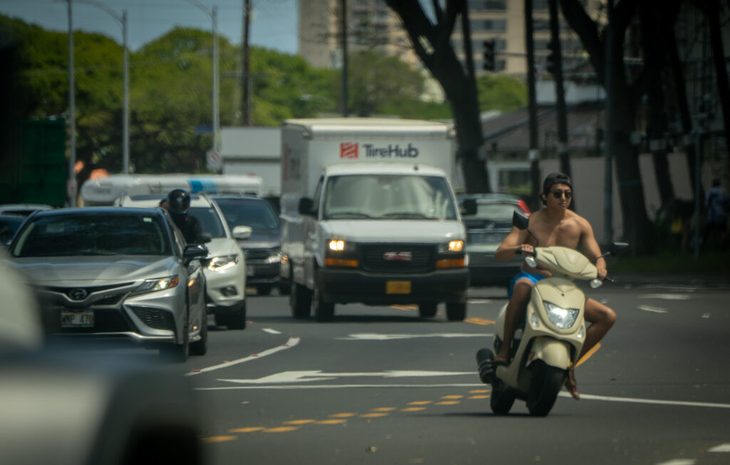 An unhelmeted moped rider turns left at Atkinson Drive from Kapiolani Blvd. March 3, 2026. (Craig Fujii/Civil Beat/2026)