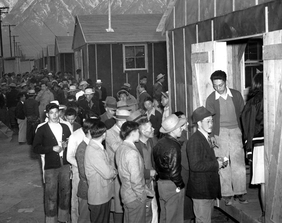 March 24, 1942, file photo of detainees waiting for their housing assignment at Manzanar War Relocation Camp in Owens Valley, Calif.