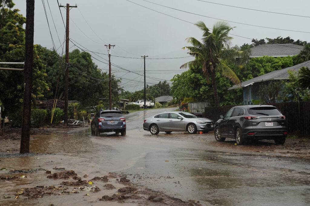 A vehicle drives through standing water on Haona Street as rain falls in Waialua Friday, April 10, 2026. The North Shore community is on edge after flooding from a recent Kona Low storm. (Kevin Fujii/Civil Beat/2026)