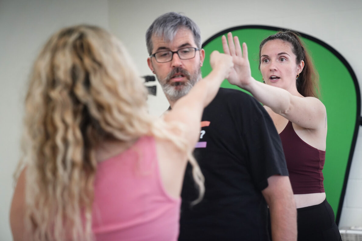 Jasmine Haley Anderson, right, gives Miriam Yazdanpanahi’s punch a target so it appears to the audience, who would be seated to the left, that Andrew Simmons is getting hit in the face Saturday, April 11, 2026, at Manoa Valley Theatre in Honolulu. Anderson is a certified instructor through Dueling Arts International. (Kevin Fujii/Civil Beat/2026)