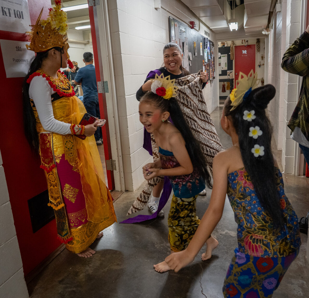 Cast and crew share a laugh backstage before a dress rehearsal of Panji and the Lost Princess April 16, 2026. From left are Chassity-Julia Daquip, Nala Widana (front), Mica Pimentel and Renaya Fisher (back to camera). (Craig Fujii/Civil Beat/2026)