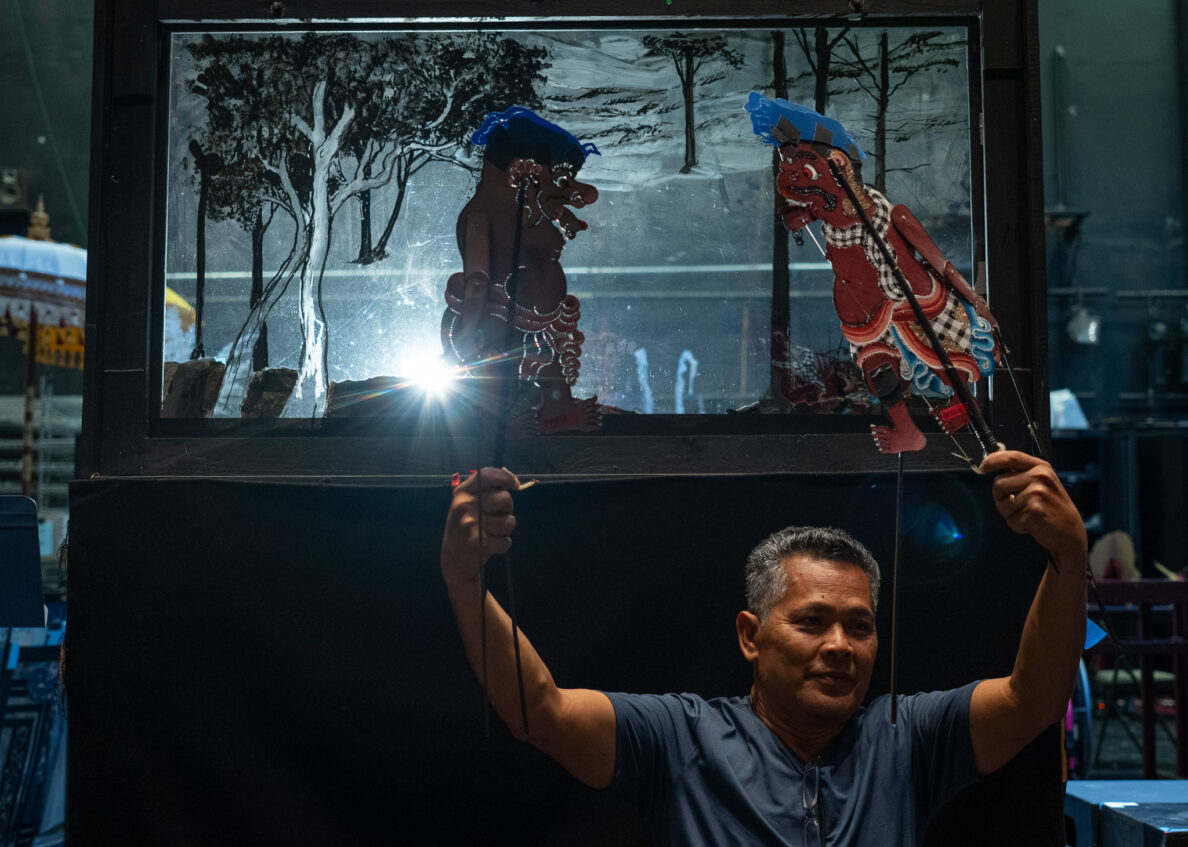 Co-director I Made Moja demonstrates how puppets and lighting are used to create moving characters on screen during a break in rehearsals at Kennedy Theatre April 16, 2026. (Craig Fujii/Civil Beat/2026)