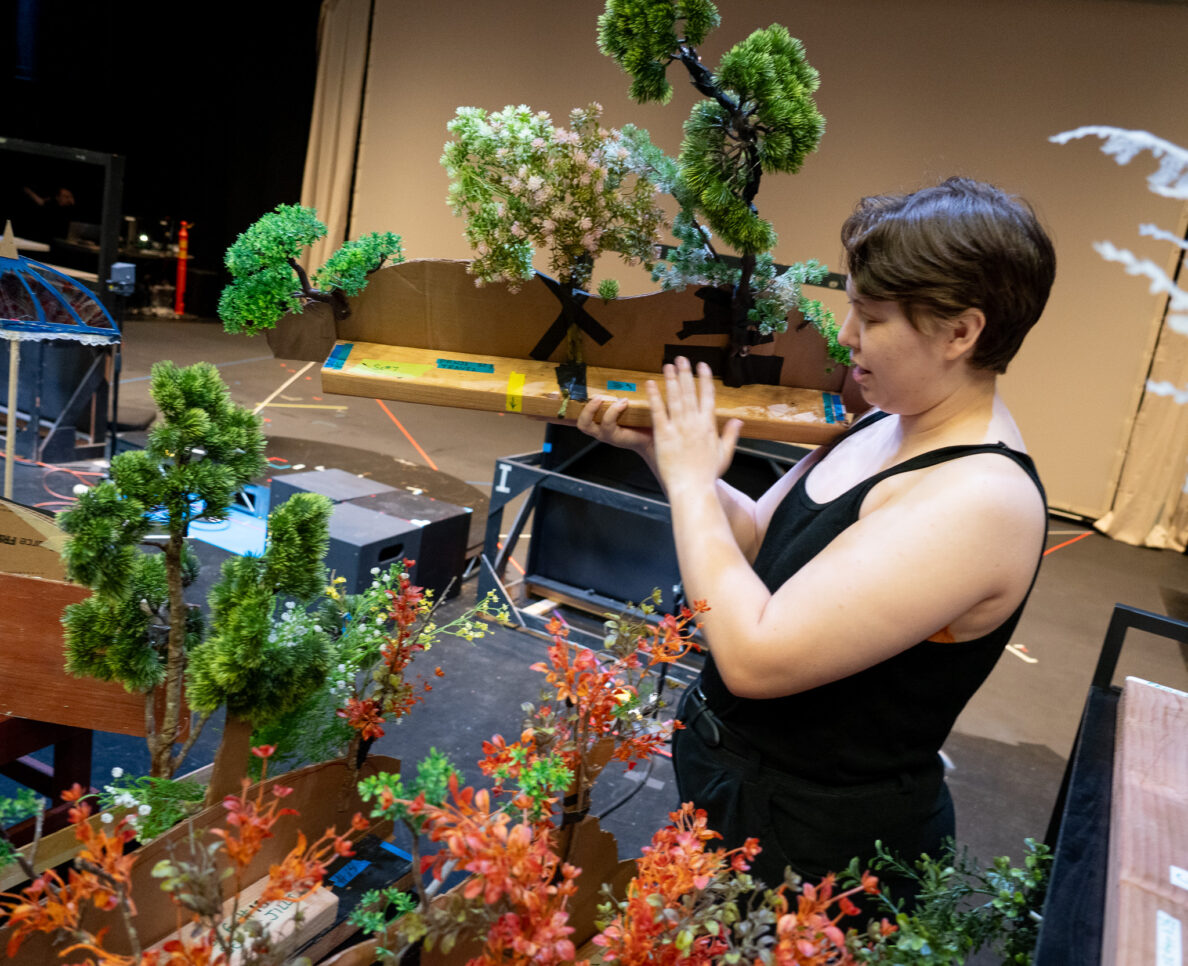 Graduate student Arlo Rowe holds shrub props that are used  as shadow landscaping pieces at the Kennedy Theatre's production of Panji and the Lost Princess April 16, 2026. (Craig Fujii/Civil Beat/2026)