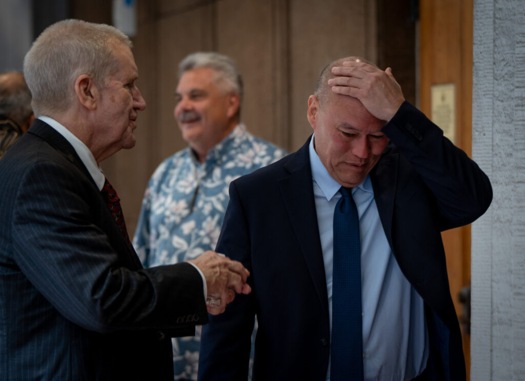 Hawai'i Chief Justice nominee Vladimir Devens rubs his head as he speaks with Honolulu Prosecutor Steve Alm during a break in his Senate confirmation hearing at the Capitol April 22, 2026. The Senate Judiciary Committee votes on Friday April 24th. (Craig Fujii/Civil Beat/2026)