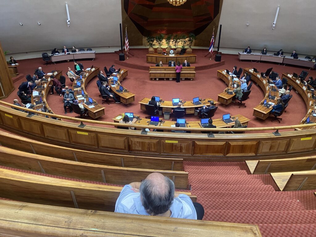 Alexander "Ali" Silvert watches with his arms crossed as the Hawaiʻi House of Representatives shelves a citizen petition he started urging them to investigate a possible case of corruption. (Chad Blair/Civil Beat/2026)