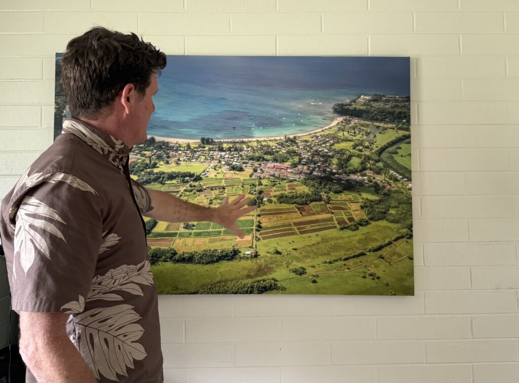 Joel Guy of the Hanalei Initiative points to an aerial photo of the town.