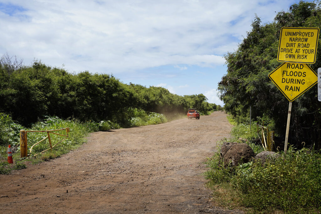 An SUV drives on the Polihale State Park access road  Tuesday, May 12, 2026, in Waimea. The Kona Low storms flooded and closed access to Polihale State Park and was expected to take longer to repair. (Kevin Fujii/Civil Beat/2026)