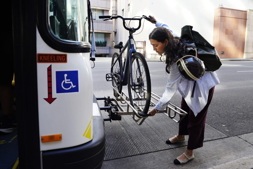 Hawai‘i Bicycling League Board of Directors president Samantha Lara puts her e-bike on TheBus Wednesday, May 13, 2026, in Honolulu. She’s commuting to work in Kāneʻohe. (Kevin Fujii/Civil Beat/2026)