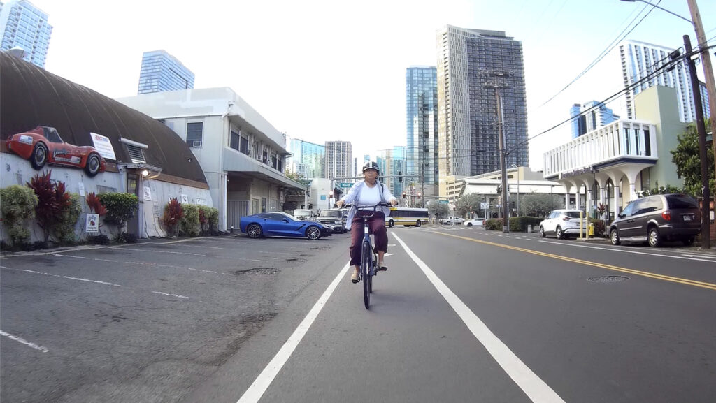 Hawai‘i Bicycling League Board of Directors president Samantha Lara rides her e-bike on Queen Street Wednesday, May 13, 2026, in Honolulu. (Kevin Fujii/Civil Beat/2026)