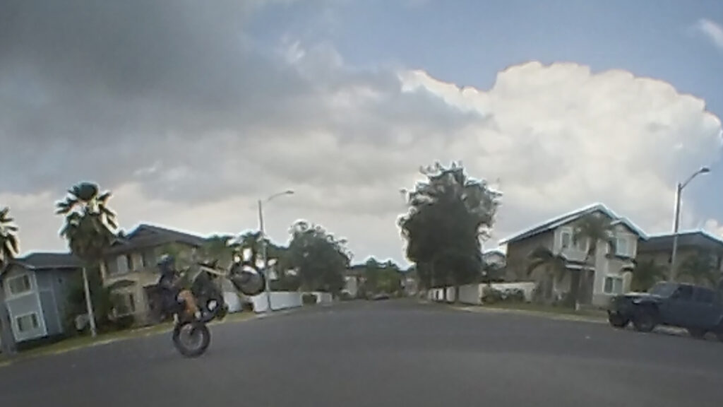An e-moto rider performs a wheelie on Kapolei Parkway Saturday, May 16, 2026, in ʻEwa Beach. (Kevin Fujii/Civil Beat/2026)