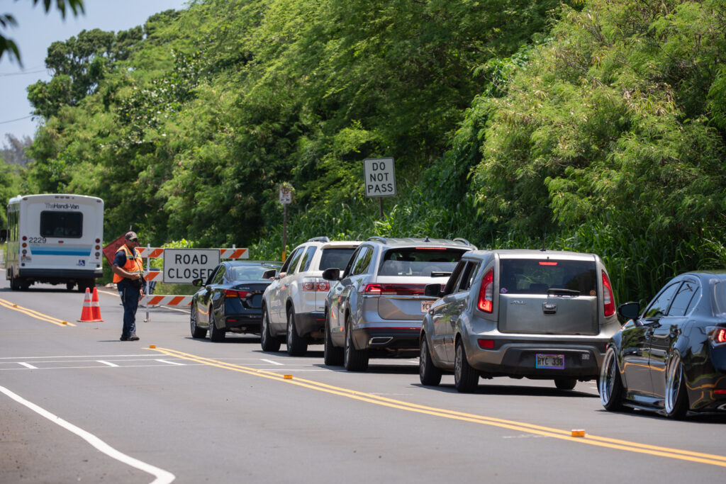Vehicles are turned around on the Haleʻiwa side of Waimea Bay as crews worked to place safety netting on the 230 foot hill above Waimea Bay May 17, 2026. Buses and Handivan were allowed through at intervals. (Craig Fujii/Civil Beat/2026)