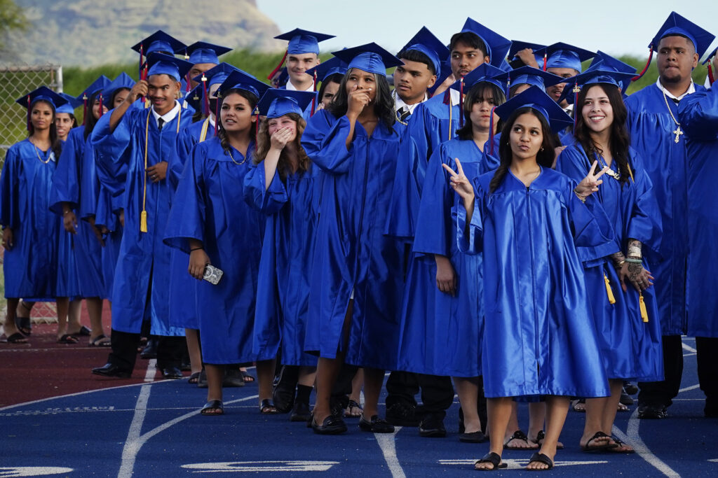 Waiʻanae High School seniors laugh and pose for friends and ʻohana in the stands for their commencement ceremony Friday, May 22, 2026, in Waiʻanae. (Kevin Fujii/Civil Beat/2026)