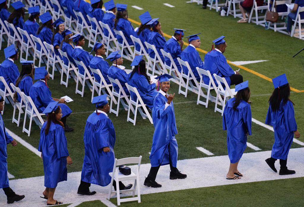 A Waiʻanae High School senior flashes a shaka on the way to being recognized during the commencement ceremony  Friday, May 22, 2026, in Waiʻanae. (Kevin Fujii/Civil Beat/2026)