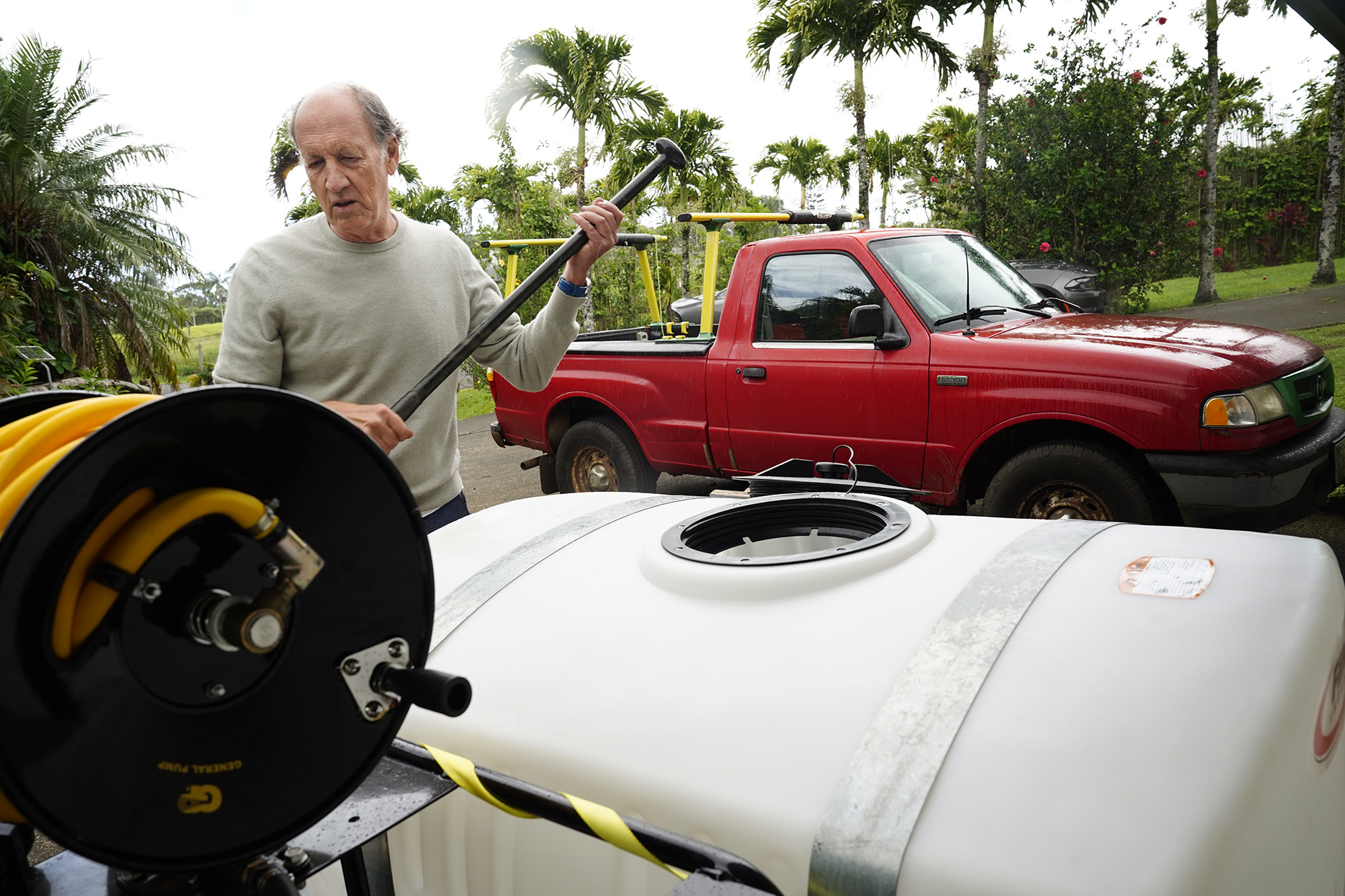 John Andrews shows how they mix citric acid to exterminate coqui frogs Tuesday, May 26, 2026, in Haʻikū. Andrews is part of a neighborhood group who invested in their own sprayer. (Kevin Fujii/Civil Beat/2024)