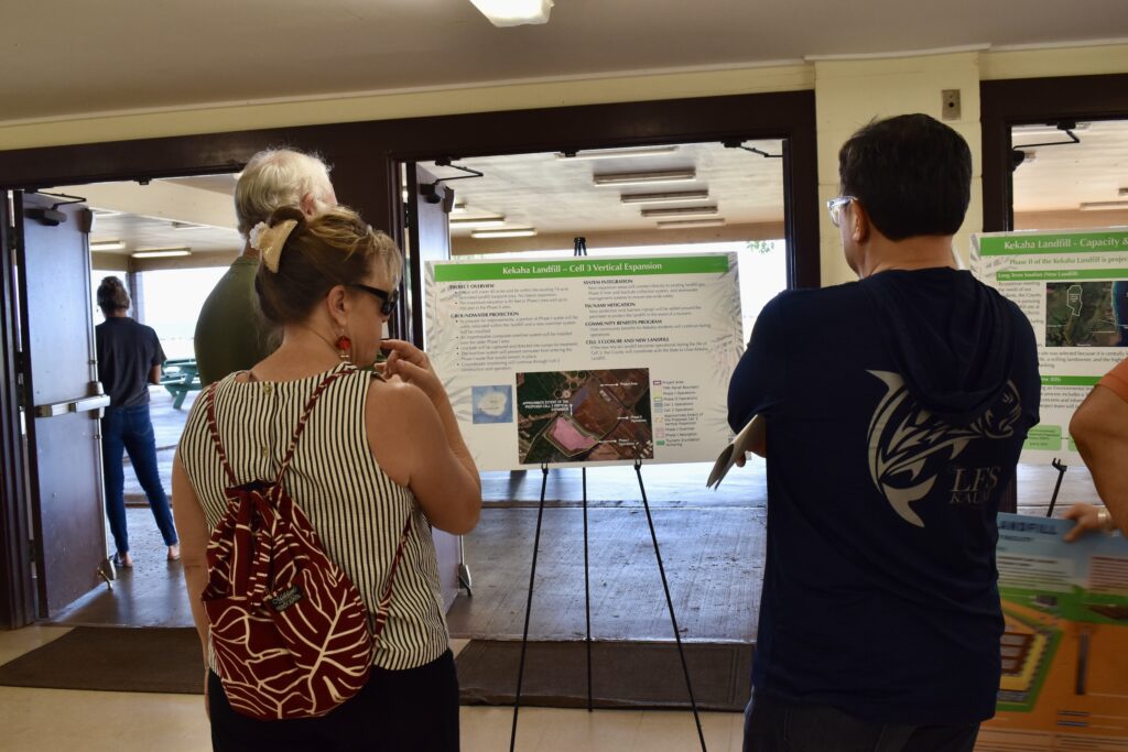 Three Kaua‘i community members read a poster board about the Kekaha landfill's Cell 3 Vertical Expansion project.